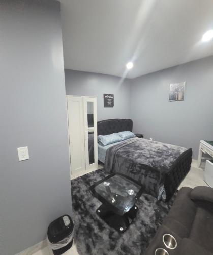 a bedroom with a bed and a couch in it at Queen Detached Studio 1 in Irvington