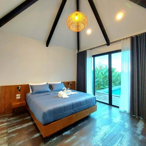 a bedroom with a large bed and a large window at Ing Suan pool villa 1 in Ao Nang Beach
