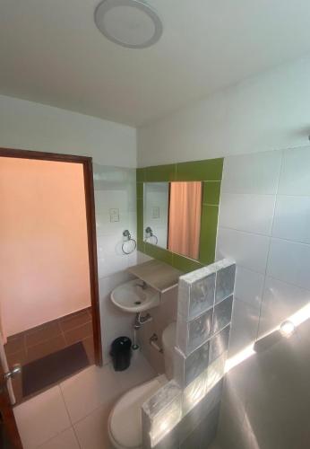 a bathroom with a sink and a toilet and a mirror at Apartaestudio con balcón cerca al mar in Puerto Colombia