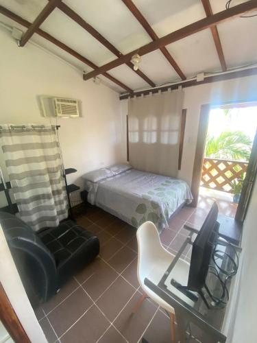 a bedroom with a bed and a desk and a chair at Apartaestudio con balcón cerca al mar in Puerto Colombia