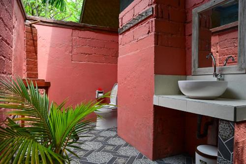 a bathroom with a sink and a toilet in a building at Kubu Pertiwi Pemuteran in Pemuteran