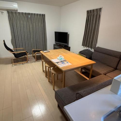 a living room with a table and a couch at Matsumoto Private Home Stay for 8 pax in Matsumoto