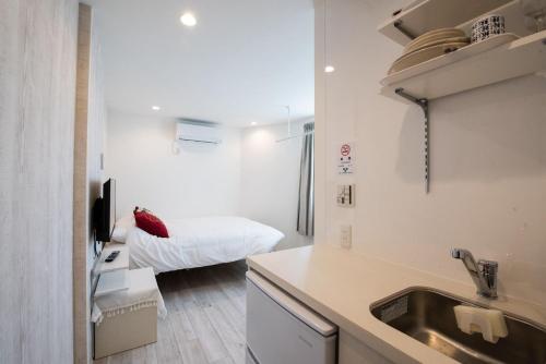 a kitchen with a sink and a bed in a room at Boa Sorte Hotel AD0515 in Tokyo