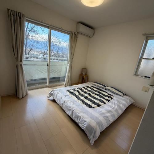 a bedroom with a bed and a large window at Matsumoto Private Home Stay for 8 pax in Matsumoto