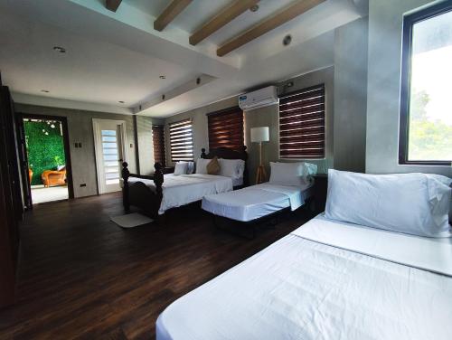 a bedroom with two beds and a living room at Anilao Mabini Sea House Diveshop and Resort in Mabini