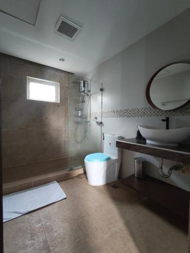 a bathroom with a shower and a toilet and a sink at Anilao Mabini Sea House Diveshop and Resort in Mabini
