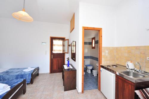 a room with a bed and a bathroom with a sink at Pension Sofia Amorgos-Katapola in Katapola