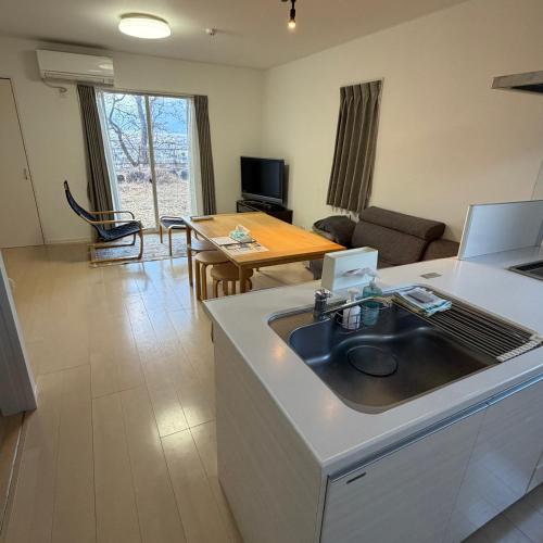 a kitchen and living room with a sink and a table at Matsumoto Private Home Stay for 8 pax in Matsumoto