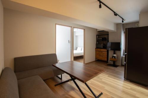 a living room with a table and a couch at NIYS apartments 01 type in Tokyo