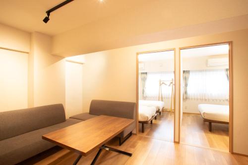 a living room with a couch and a table at NIYS apartments 01 type in Tokyo
