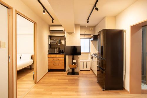 a kitchen with a black refrigerator and a bedroom at NIYS apartments 01 type in Tokyo
