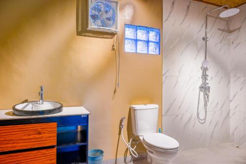 a bathroom with a toilet and a sink and a shower at Livin didesa in Munduk