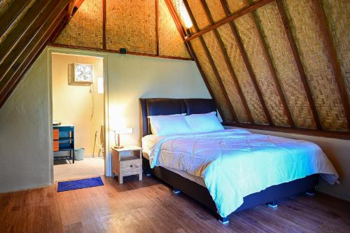 a bedroom with a bed with a wooden ceiling at Livin didesa in Munduk
