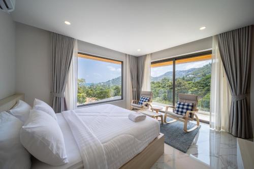 a bedroom with a large bed and large windows at Villa M3 De Samui in Nathon Bay