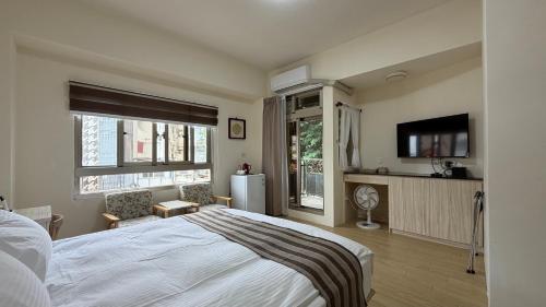 a bedroom with a large bed and a tv in it at 且市隱 in Hualien City