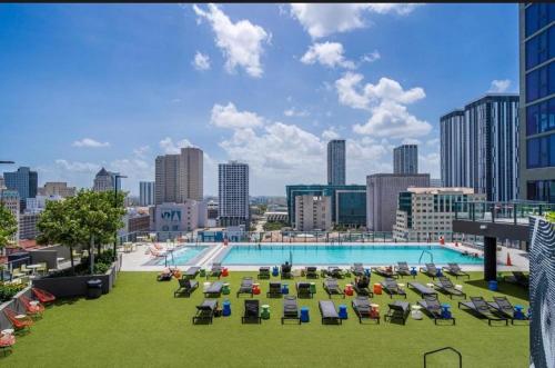 a large pool with lounge chairs and a city skyline at Miami-Brickell Luxury 2BR-2BATH with skyline VIEWS - walking distance to KASEYA-HEAT ARENA & BAYSIDE - Port of MIAMI cruise ships in Miami