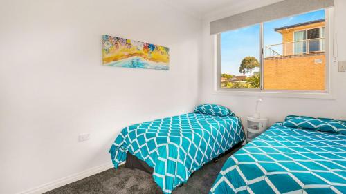 a bedroom with two beds and a window at Cowes Beachfront Penthouse in Cowes
