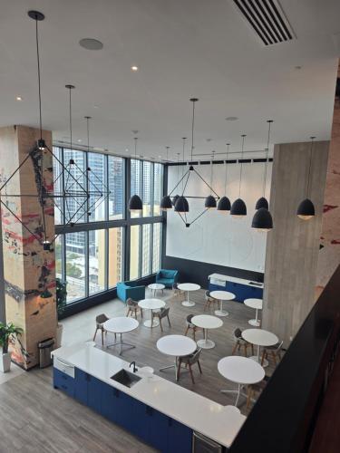 a cafeteria with tables and chairs and windows at Miami-Brickell Luxury 2BR-2BATH with skyline VIEWS - walking distance to KASEYA-HEAT ARENA & BAYSIDE - Port of MIAMI cruise ships in Miami