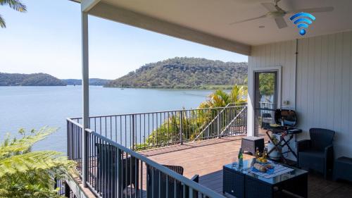 a house with a balcony with a view of the water at Joey's Cottage in Mooney Mooney