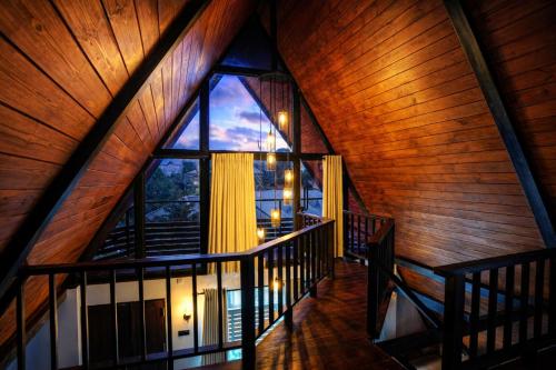 an attic room with a large window in a cabin at Kubana in Nuwara Eliya