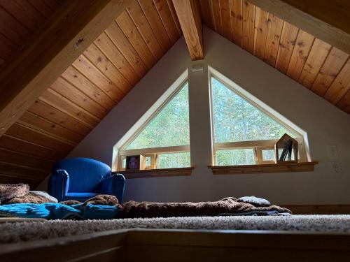 a bedroom with a large window in a attic at Creekside Cabin - Ski Chalet in Packwood