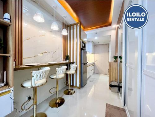 a kitchen with a bar with stools in a room at Modern Style 2-BR in SMDC in Iloilo City