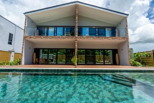 a house with a swimming pool in front of a house at Tides Apartments in Nadi