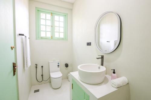 a white bathroom with a sink and a mirror at Allude Villa Weligama in Weligama