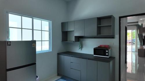 a kitchen with a counter and a microwave in it at บ้านมั่งมี ขอนแก่น in Ban Si Than