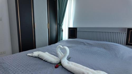 two swans made out of towels on a bed at บ้านมั่งมี ขอนแก่น in Ban Si Than