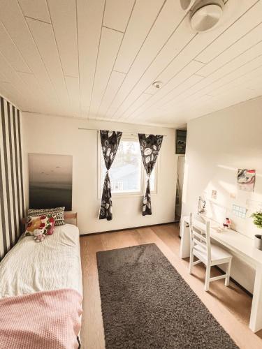 a bedroom with a bed and a desk and a table at Beautiful Home in Sipoo in Söderkulla