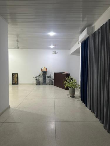 an empty room with a hallway with plants and curtains at Solace More Hotel - Borella 2 in Colombo