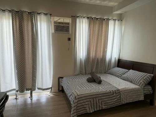 a bedroom with a bed with two pillows on it at Wide studio Antara Residences Talisay in Talisay