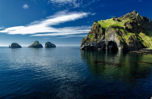 a group of large rocks in the water at Luxury Ocean Villas in Vestmannaeyjar