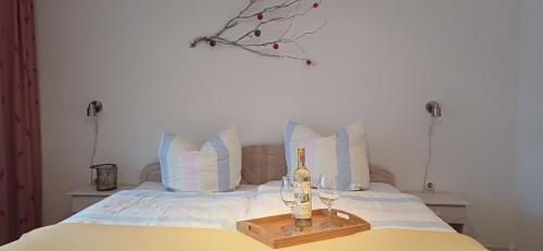 a bed with a bottle of wine and two glasses at Hauptstraße 19 in Zachenberg