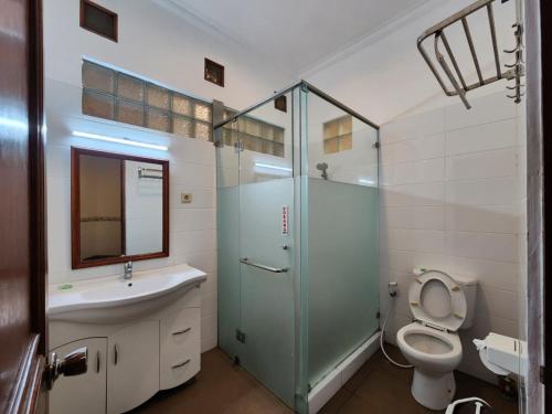 a bathroom with a toilet and a sink and a shower at Kulem Cisitu in Bandung