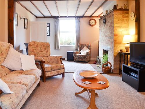 a living room with a couch and a fireplace at Pam's Plaice in Offord Cluny