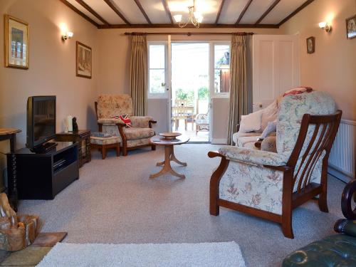 a living room with a couch and chairs and a tv at Pam's Plaice in Offord Cluny