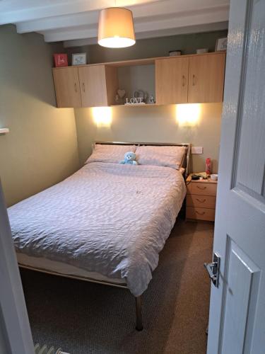 a bedroom with a bed with a teddy bear on it at The Old Chip Shop in Ilchester
