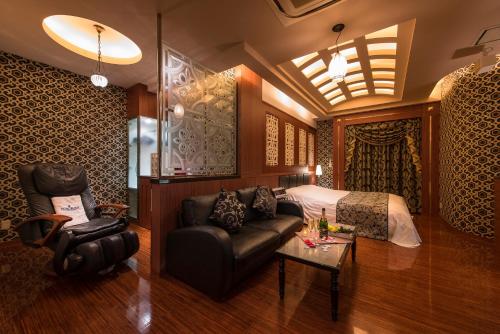 a bedroom with a bed and a couch and a table at ホテルルアン横浜 in Kikuna