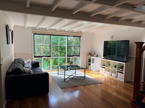 a living room with a couch and a tv at Bonza Family Retreat in Kalorama