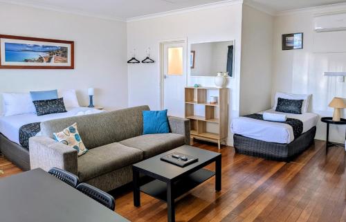a living room with a couch and a bed at Ocean Drive Motel in Bunbury