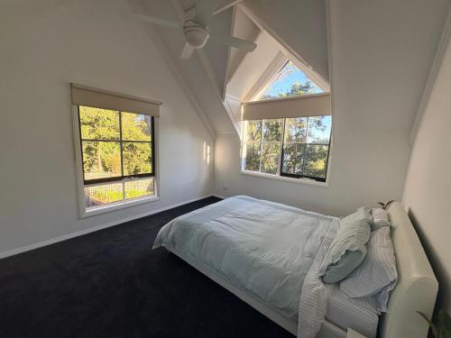 a bedroom with a bed and two windows at Bonza Family Retreat in Kalorama