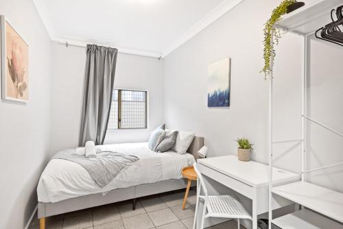 a white bedroom with a bed and a desk at Signature Double Room in Auburn - Shared Bathroom in Sydney