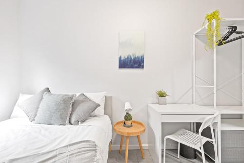 a white bedroom with a bed and a desk at Signature Double Room in Auburn - Shared Bathroom in Sydney