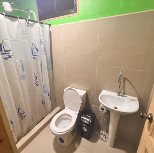 a bathroom with a toilet and a sink at Mayra Campground in Savegre