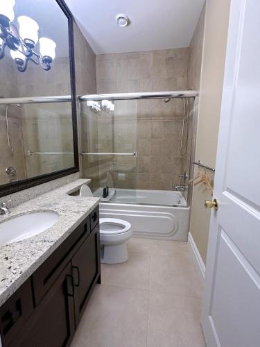 a bathroom with a toilet and a tub and a sink at Moon rooms in Vancouver