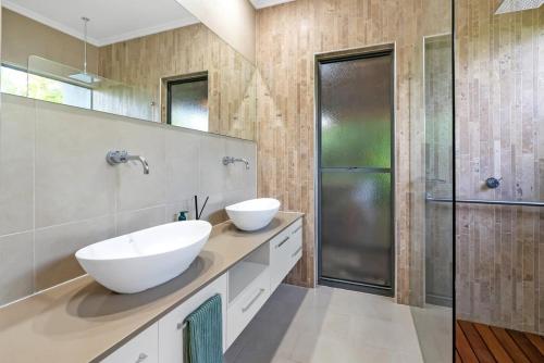 a bathroom with two sinks and a shower at Belle Escapes Samaya in Palm Cove