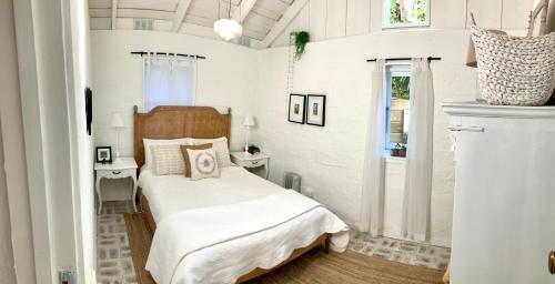 a small bedroom with a bed and a window at ONE WEE COTTAGE Bring your dog and enjoy a cosy romantic winter fireside stay in Healesville