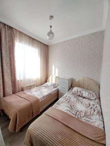 a bedroom with two beds and a window at Tom House Garden in Tsaghkadzor